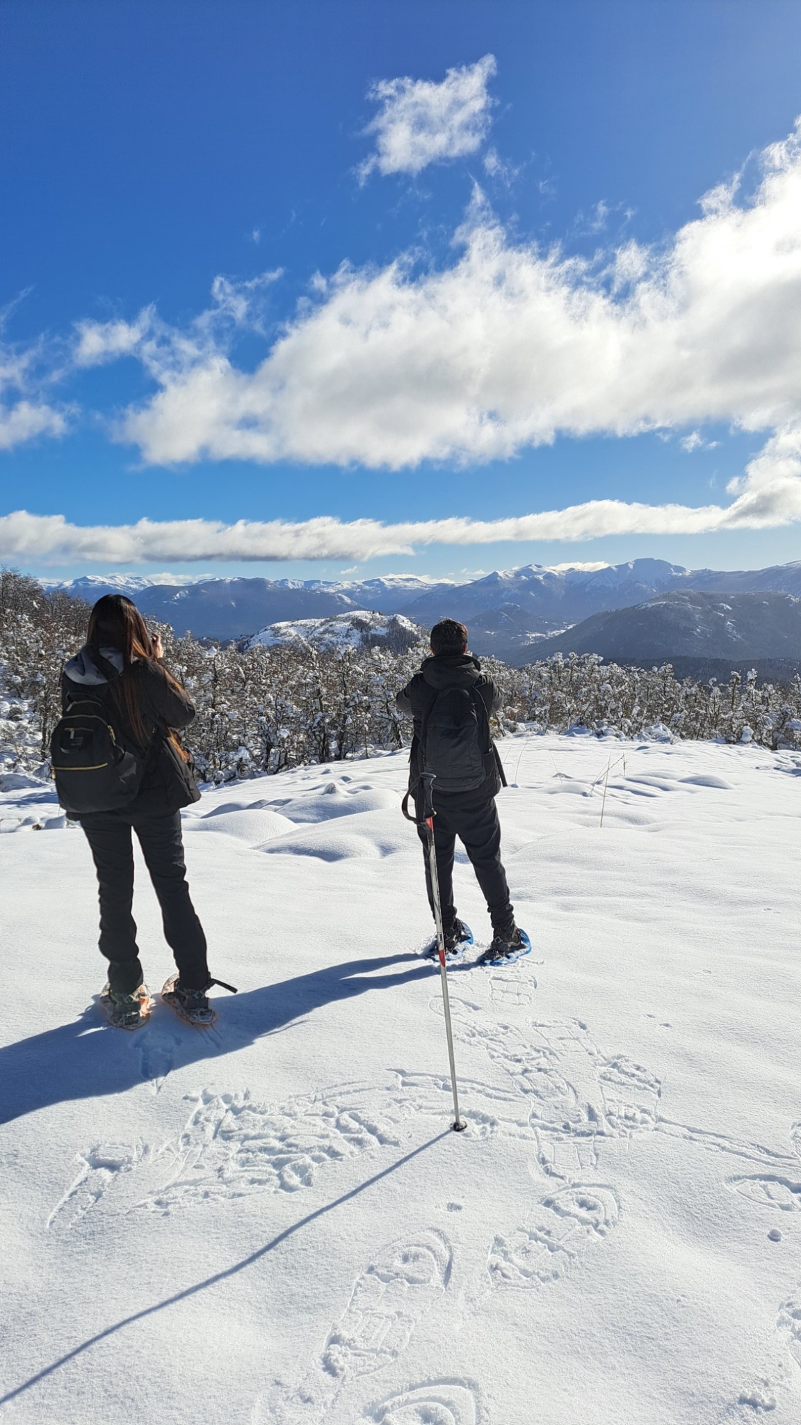 Visitors snowshoeing through a snowy mountain landscape